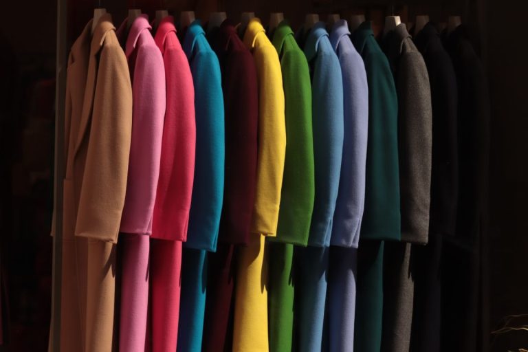 Cappotti da donna tutti uguali in colori diversi, immagine simbolica della produzione di massa nell’industria della moda, tema centrale del libro della moda anticapitalista